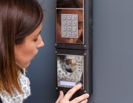 Woman pushing the button and talking on the intercom